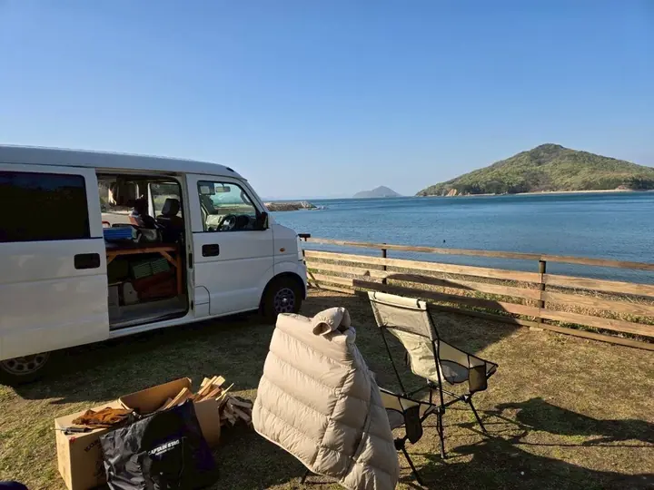 Suzuki Every DA64V camper van parked by the sea with camping gear