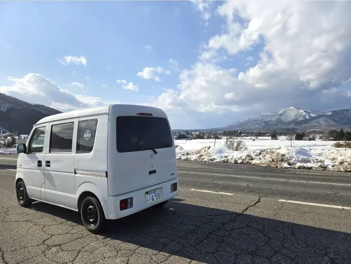 White Suzuki Every DA64V on a snowy mountain road